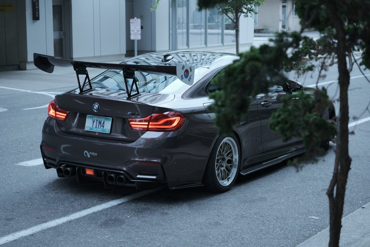 A BMW photographed from the rear with a track-style rear wing